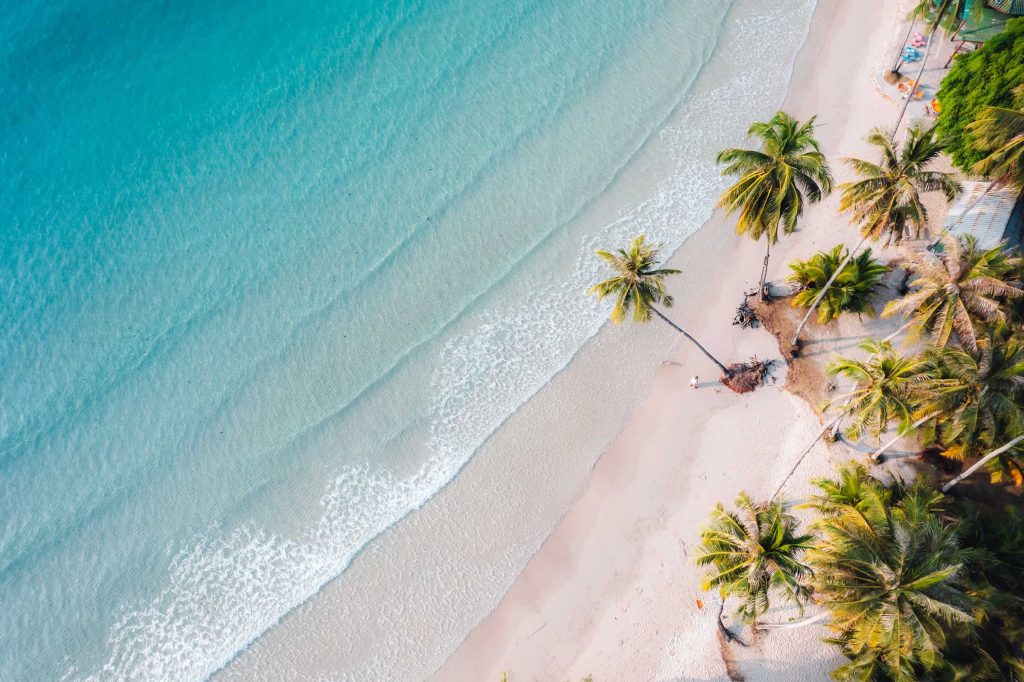 Azuurblauwe zee, strand en palmbomen